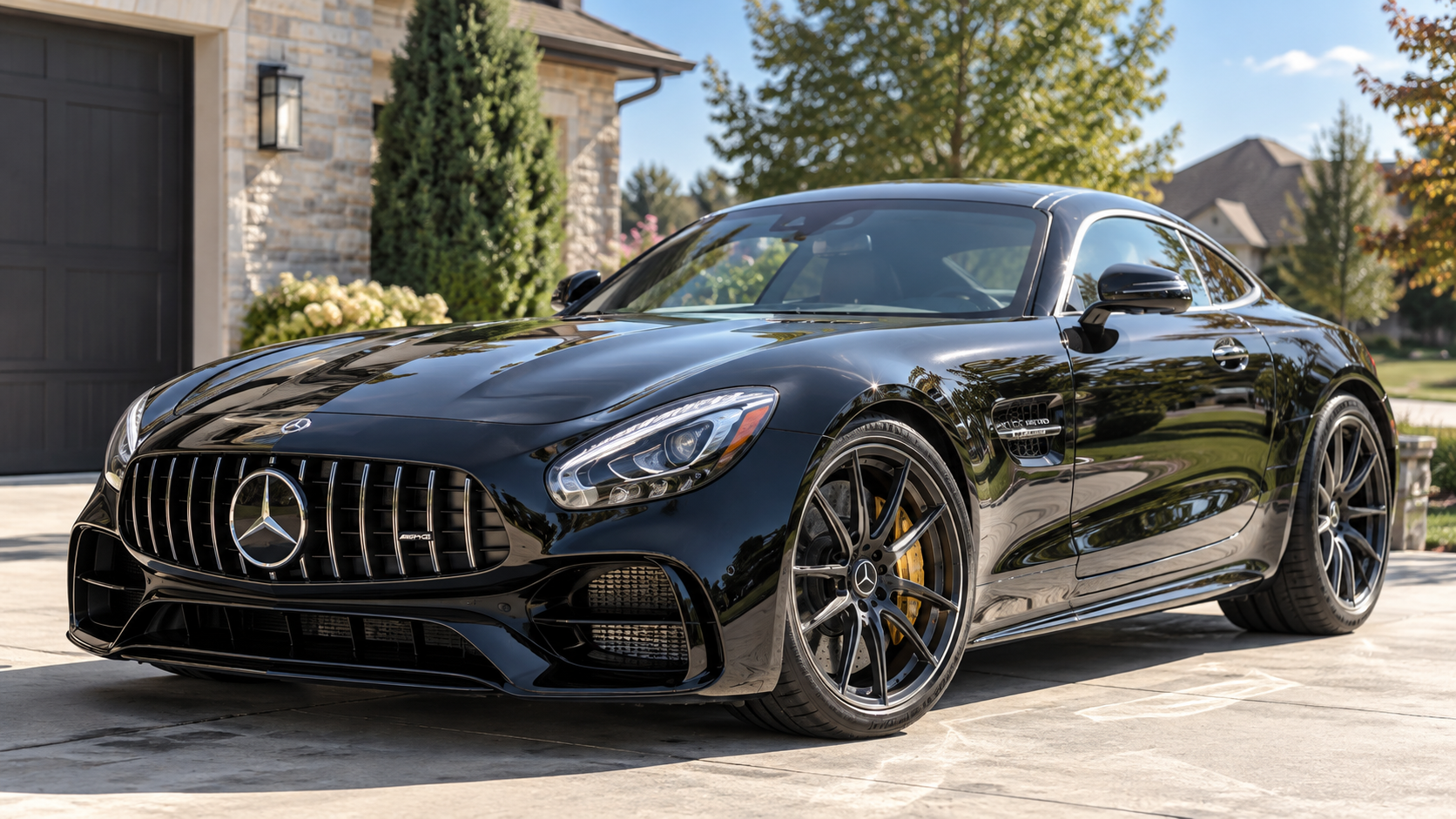 Glossy black Mercedes-AMG coupe parked on a luxury residential driveway