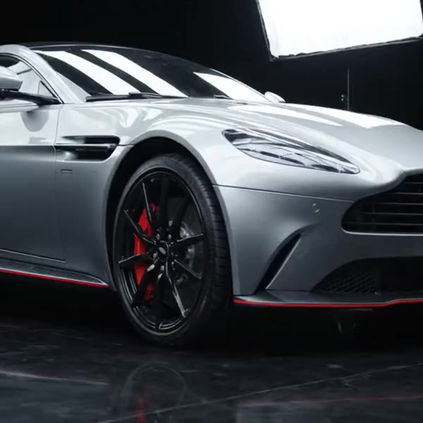Satin silver Aston Martin Vantage with red brake calipers in a black detailing studio